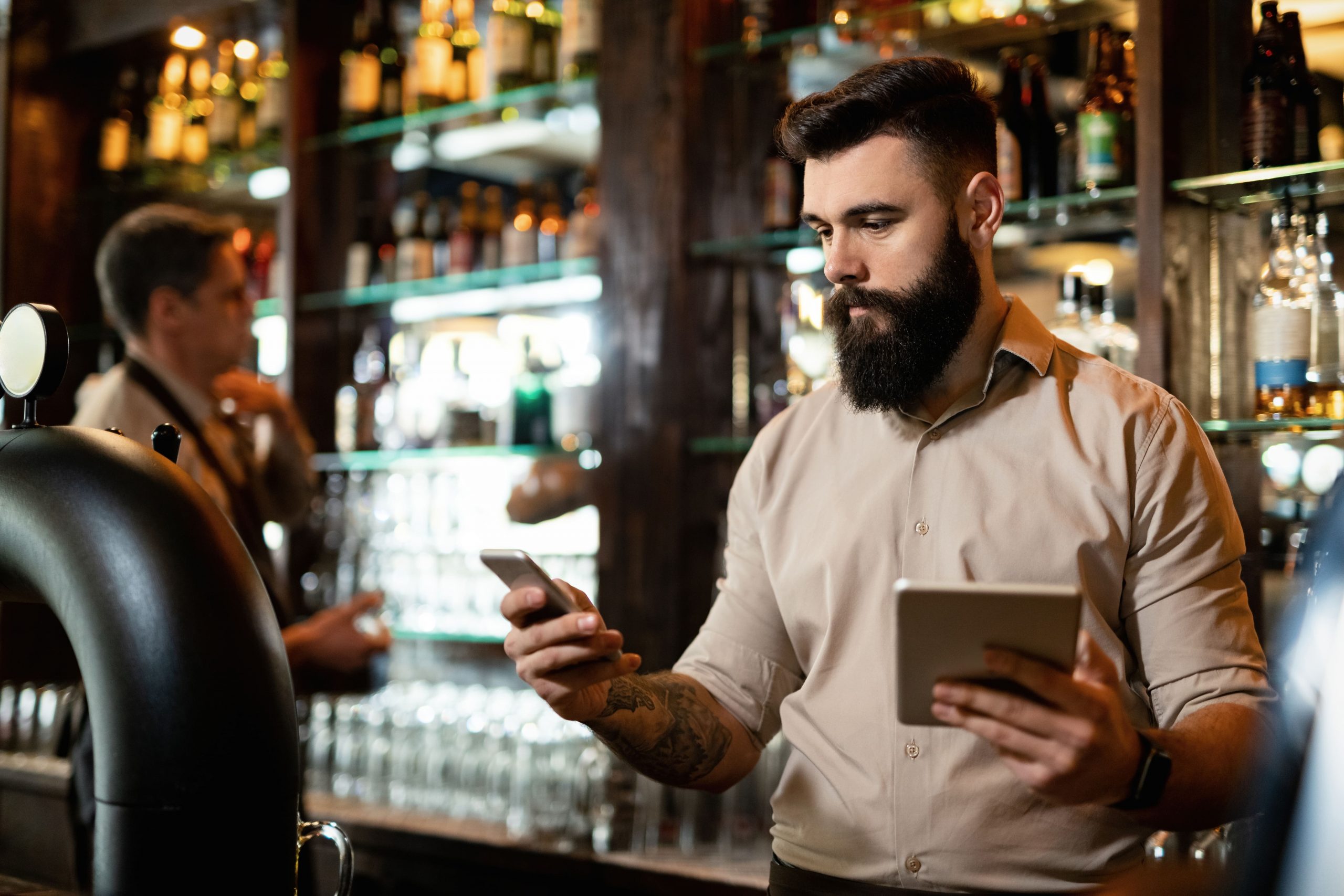 Joven camarero de un bar atendiendo los pedidos online